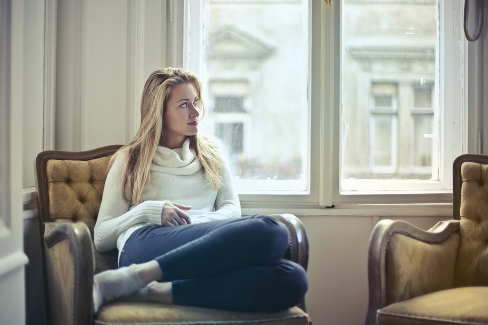 woman sitting on brown armchair