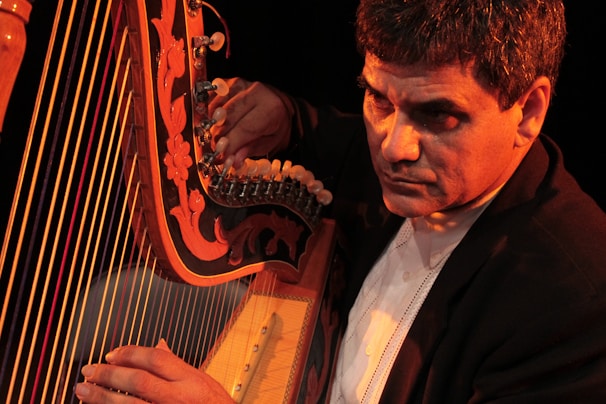 Close-up of a harpist’s fingers plucking strings during a serene performance.