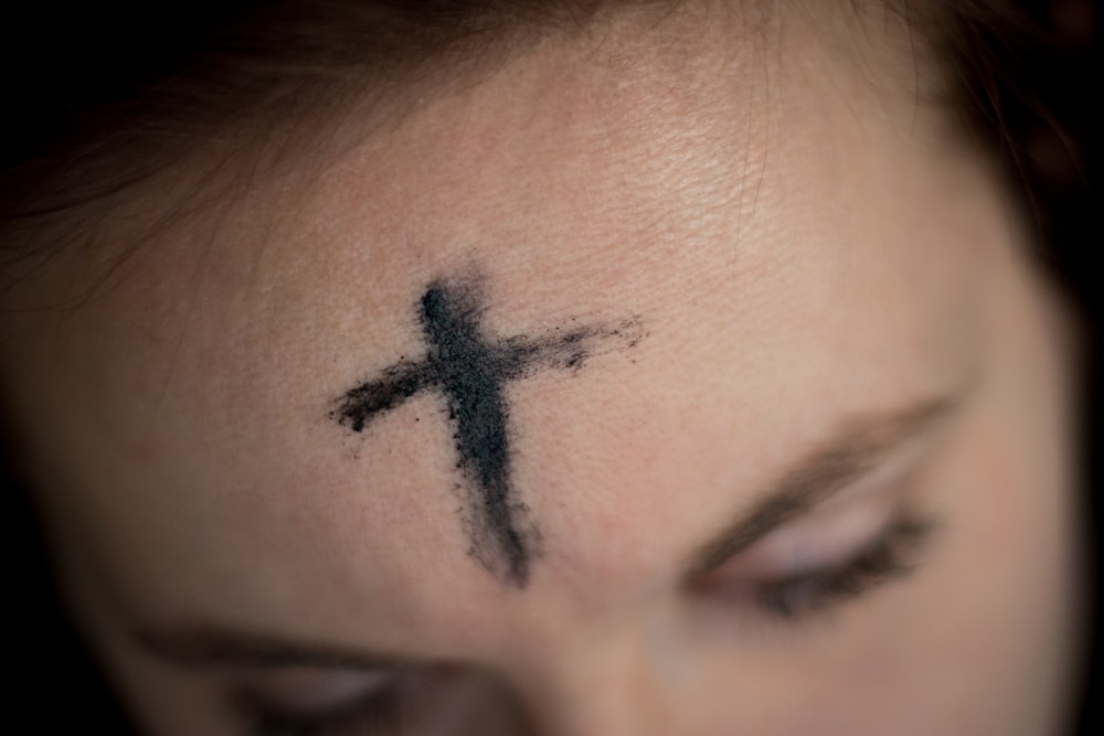 croix noire sur le front de la personne