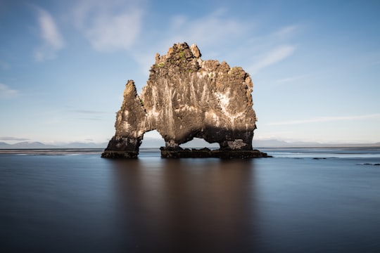 rock monolith surrounded body of water in Hvitserkur Iceland