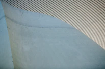Close-up of smooth, freshly poured concrete with a modern building backdrop.