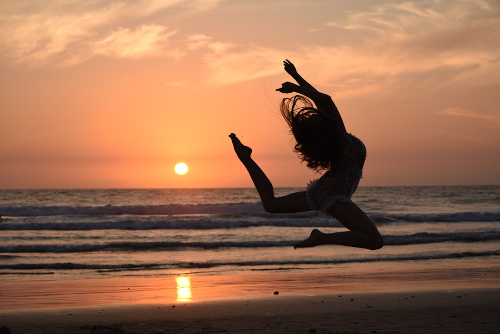 silhouette of woman jumping during golden hour