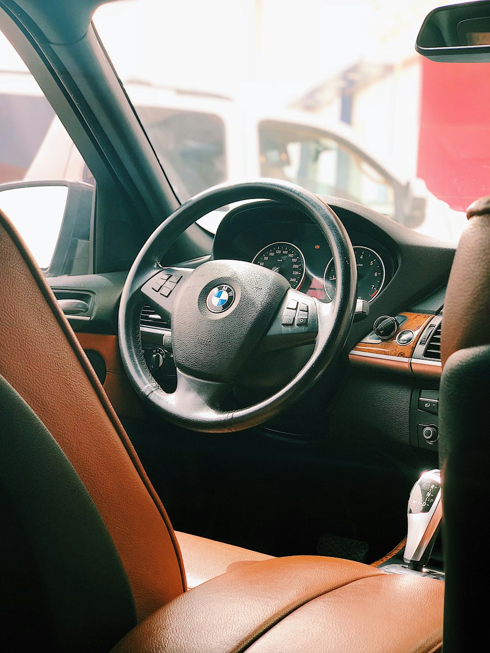 Interior do veículo BMW perto da van branca durante o dia