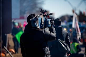 man carrying professional camera