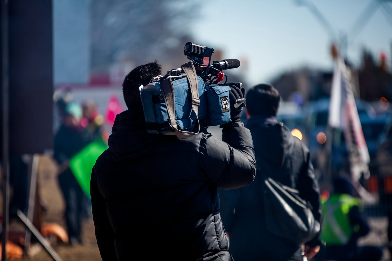 Reporter carrying a professional camera on assignment