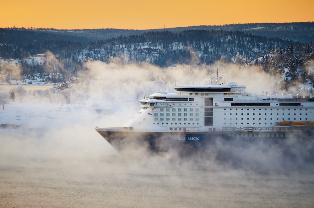 white and bleu cruise ship near mountain at daytime