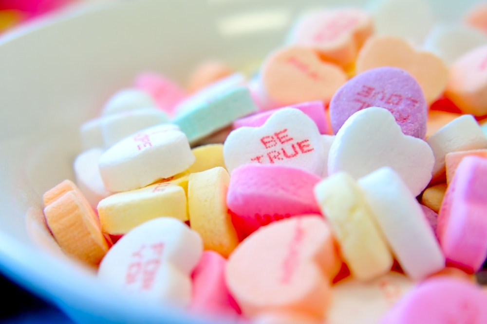 assorted hear-shape candies on white bowl