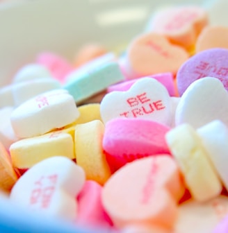 assorted hear-shape candies on white bowl