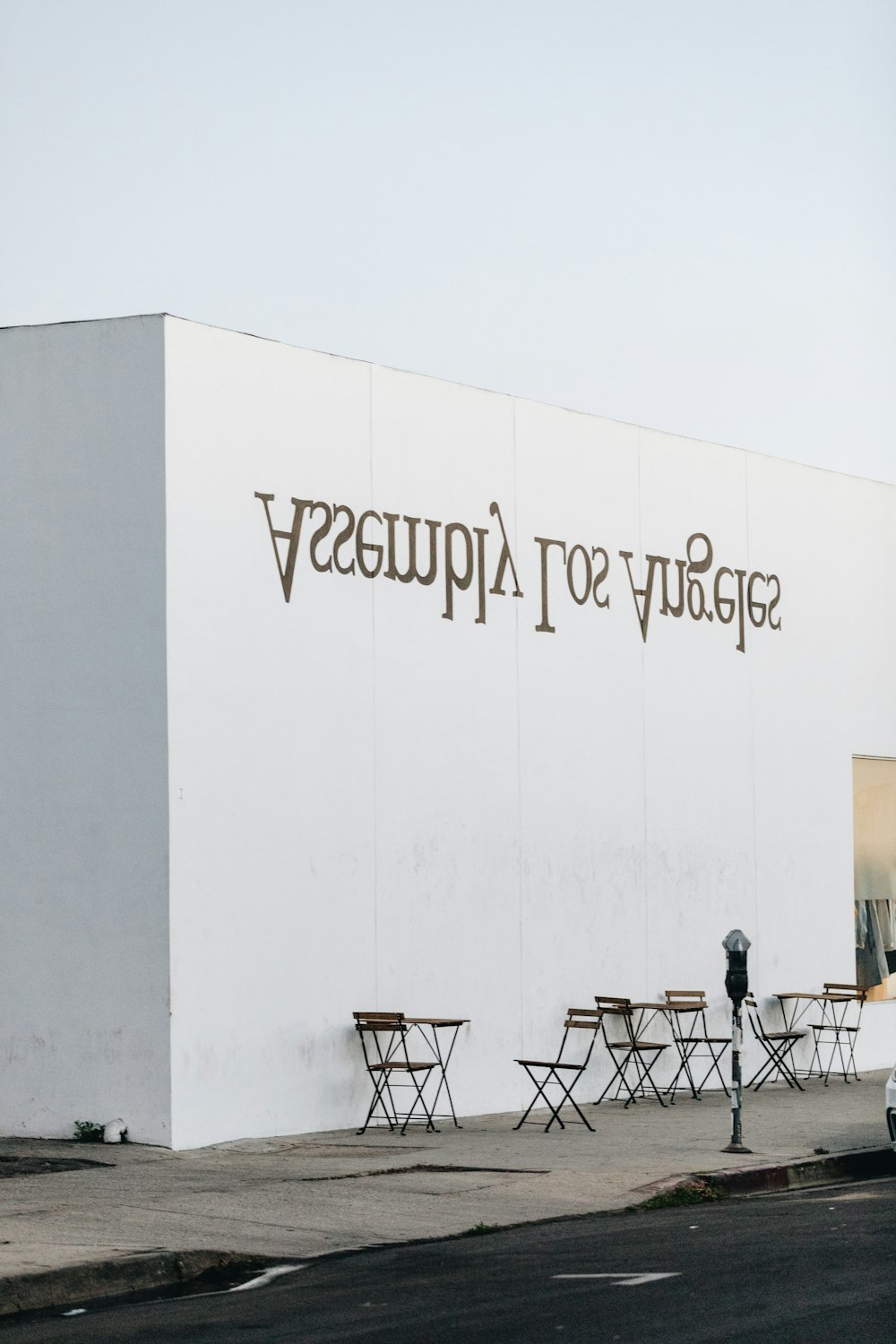 closeup photo of three set of tables and chairs beside white painted wall