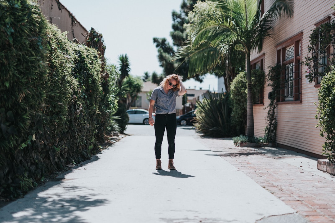 woman standing on street near house