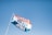 A flag with the words 'Sundays Are For Jesus' printed in large, bold letters. The flag has three horizontal stripes: orange, white, and blue. The flagpole is angled towards the left and is set against a clear blue sky, indicating a bright, sunny day.