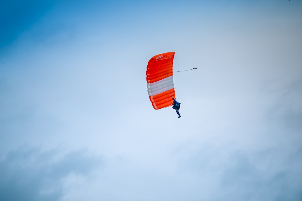 빨간색과 흰색 낙하산을 타고 있는 사람