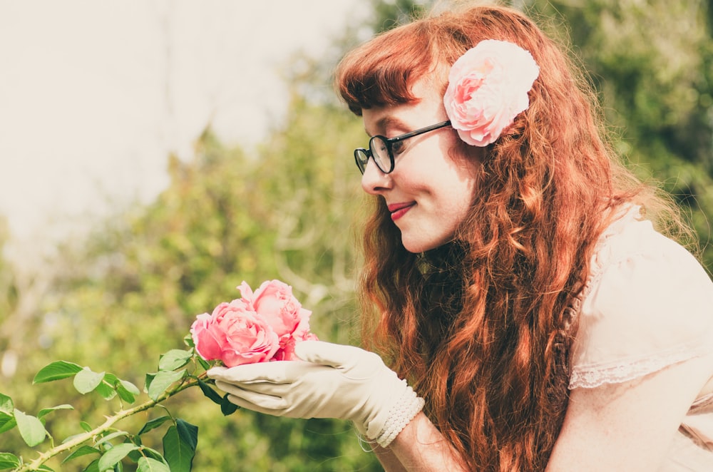 mulher segurando a flor cor-de-rosa