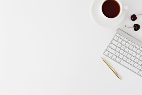 Magic Keyboard beside mug and click pen