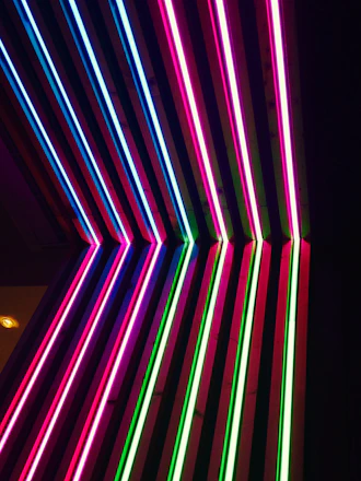 A sleek grid of glowing neon pink language cards floating against a deep black cosmic background.