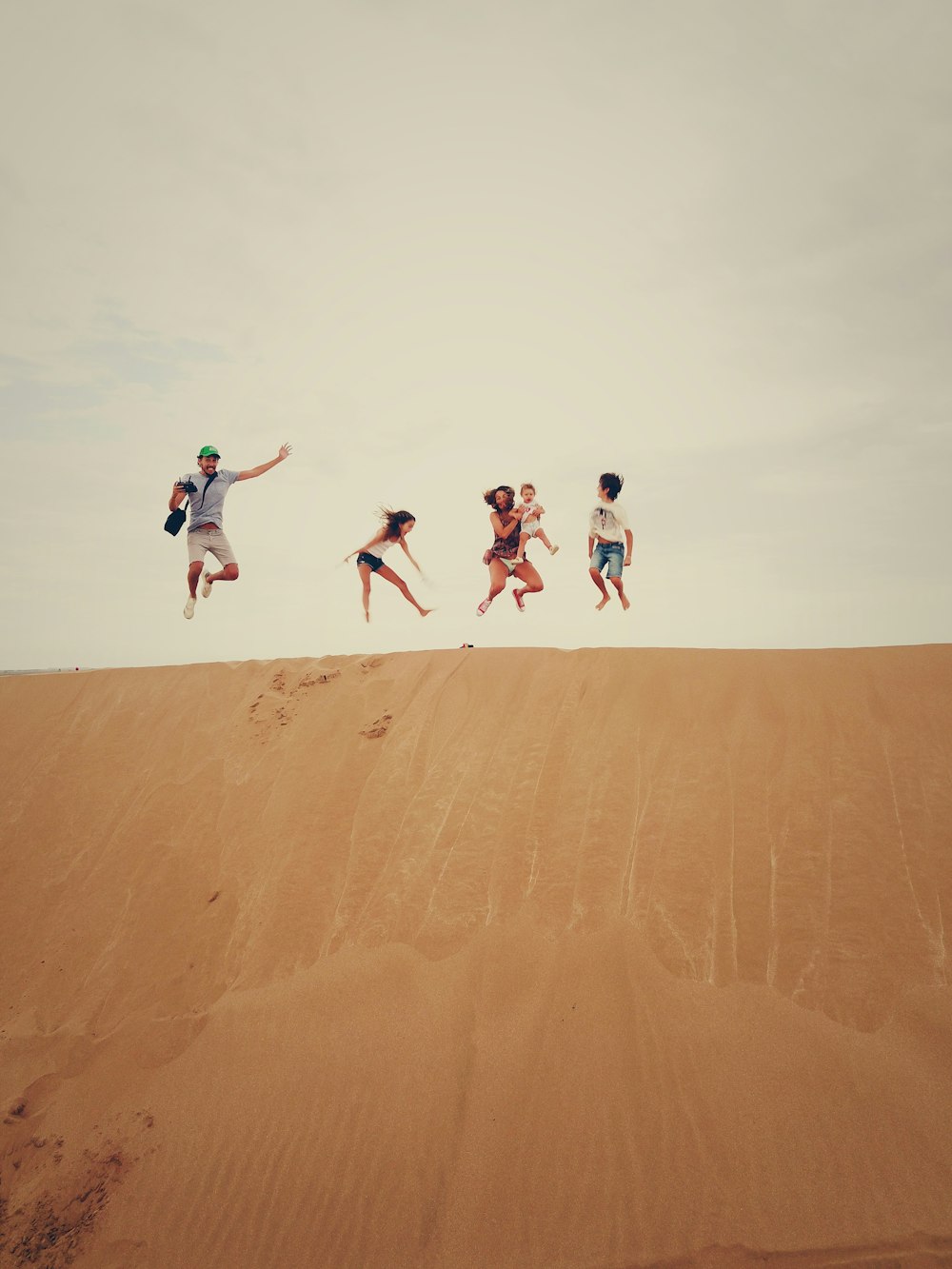 people jumping on sand