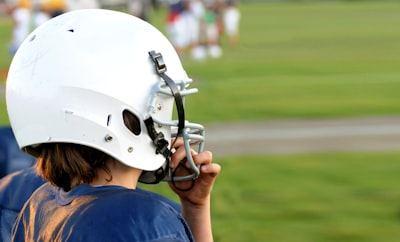 man wearing football helmet super bowl teams background