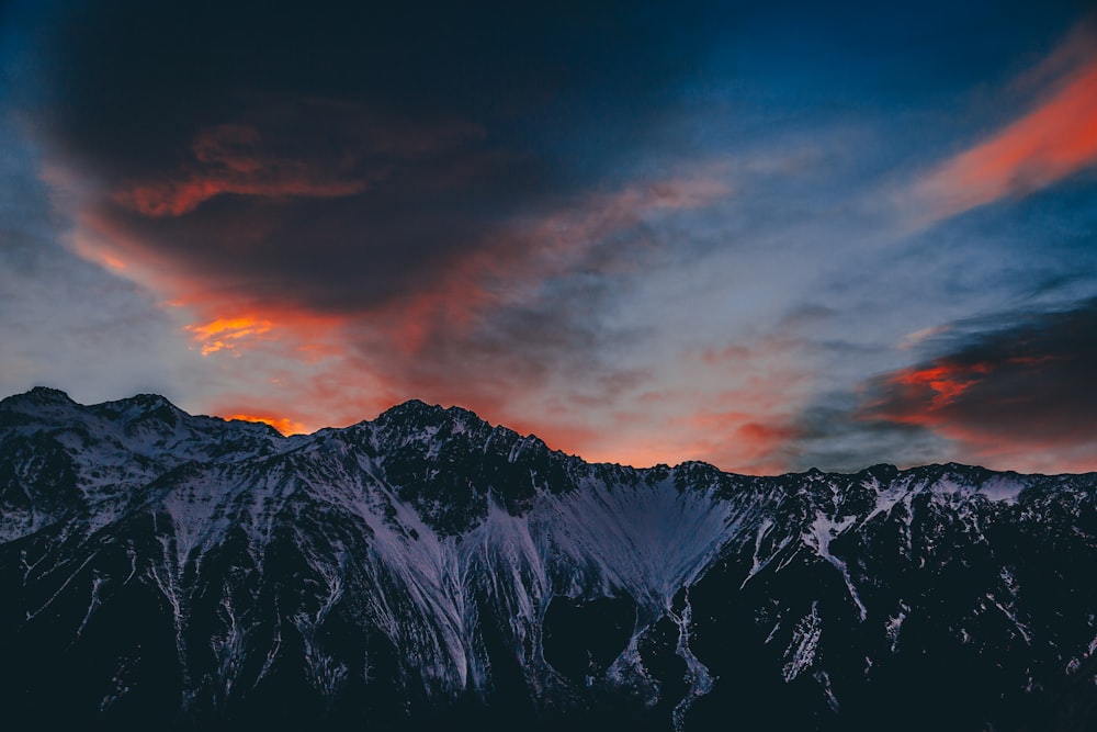 fotografia de paisagem da montanha coberta de neve durante o crepúsculo