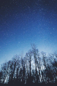 A serene image of a glowing kundali chart overlaying a peaceful night sky filled with stars.