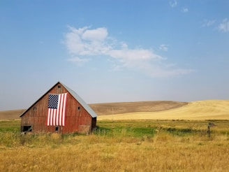 flag of United States of America hanged on brown house during daytime