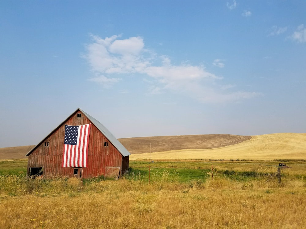 flag of United States of America hanged on brown house during daytime