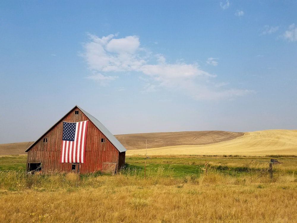 낮 동안 갈색 집에 매달린 미국 국기