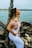 woman leaning on tree with hands in right pocket