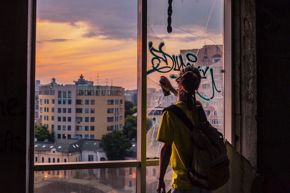 Donna che fa l'arte dei graffiti nel vetro della finestra