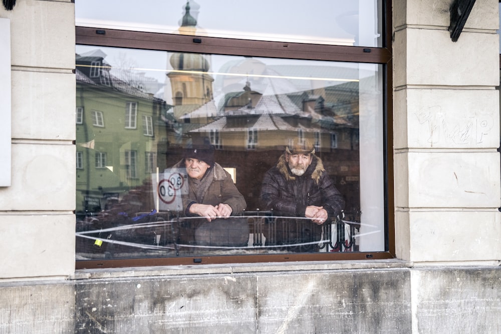 Dos hombres de pie junto a la ventana