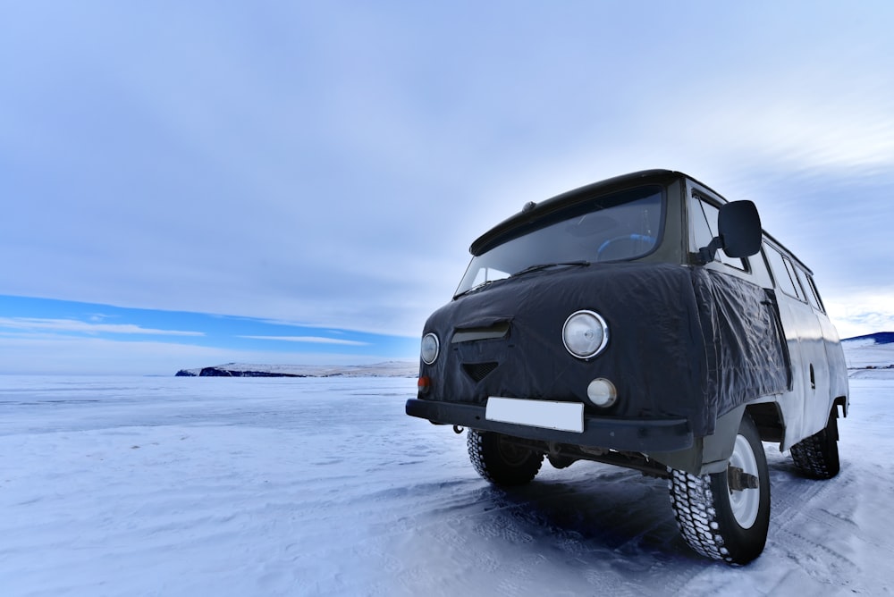 gray vehicle on snowfield duing daytime