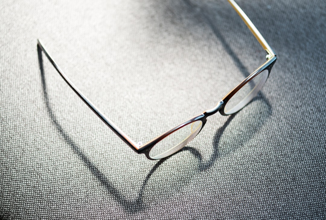 eyeglasses with white frames on grey table