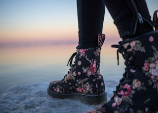 person wearing black and pink floral boots