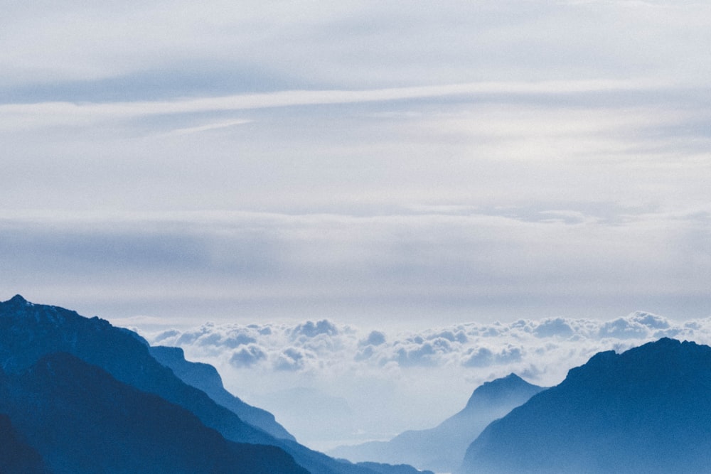 silhouette of mountain with clouds during daytime