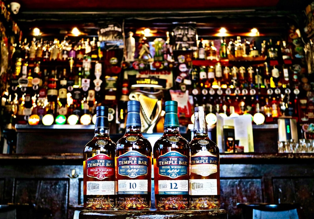 four whiskey bottles in bar counter