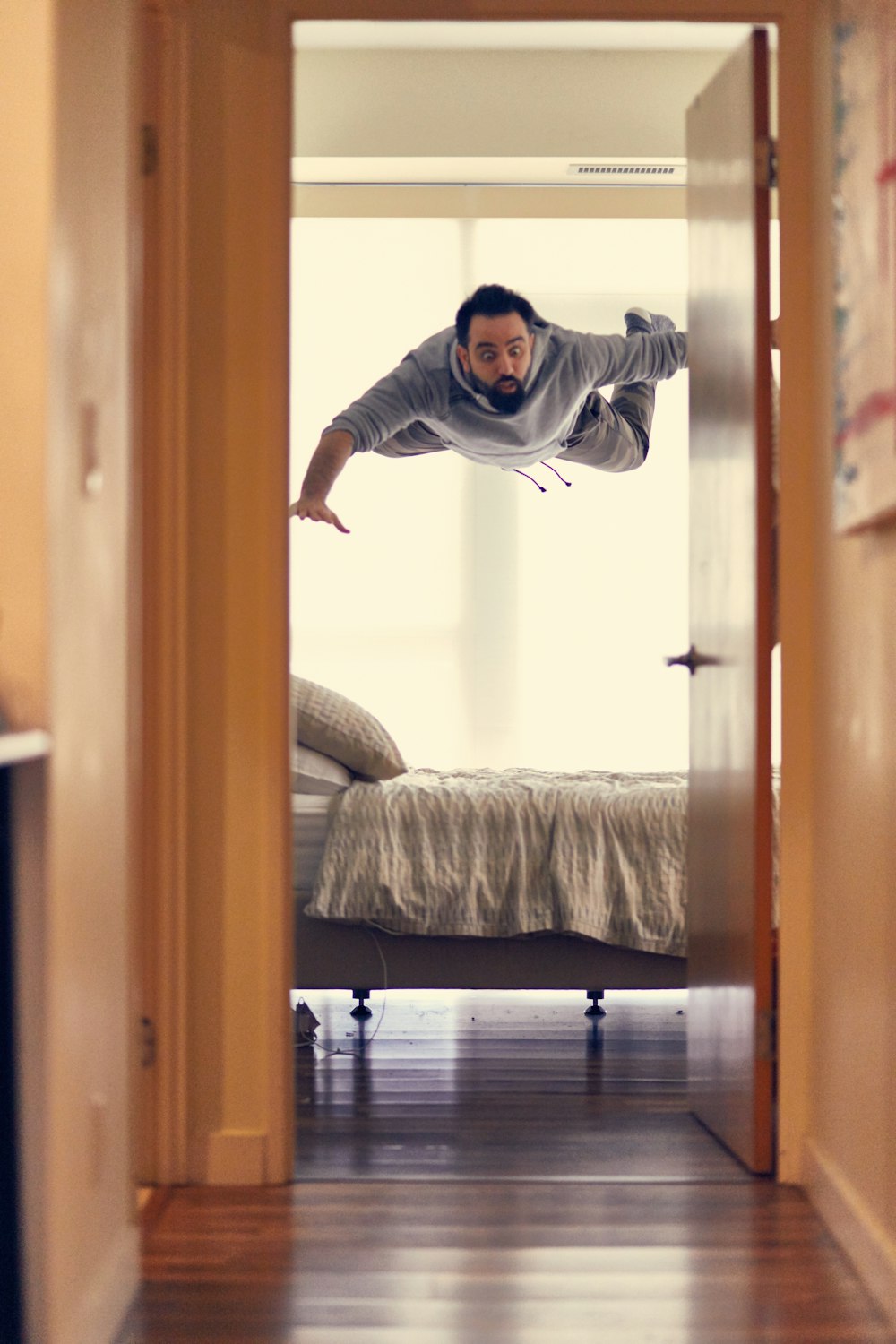 man falling from ceiling on bed