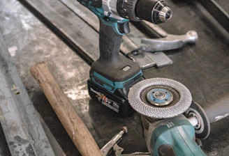 green Makita cordless drill near angle grinder