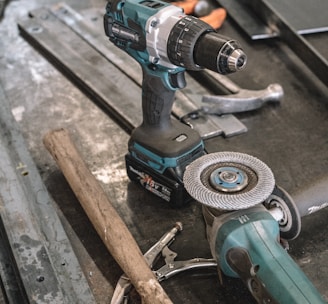 green Makita cordless drill near angle grinder