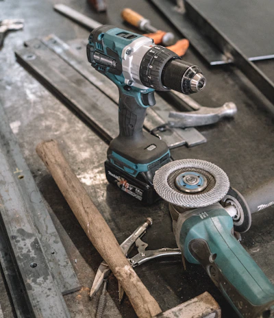 green Makita cordless drill near angle grinder
