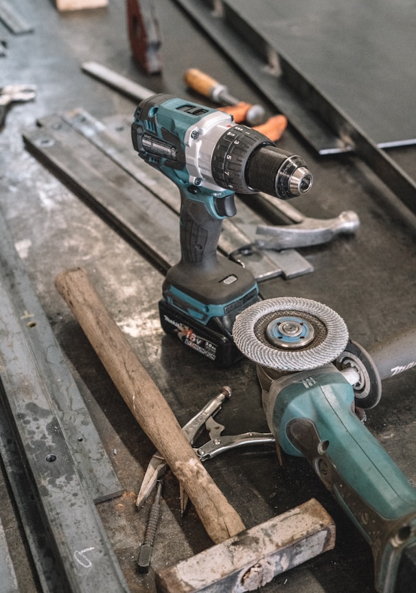 green Makita cordless drill near angle grinder