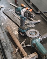 green Makita cordless drill near angle grinder