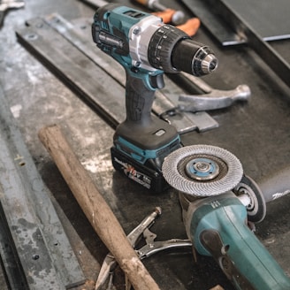 green Makita cordless drill near angle grinder