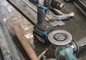 green Makita cordless drill near angle grinder