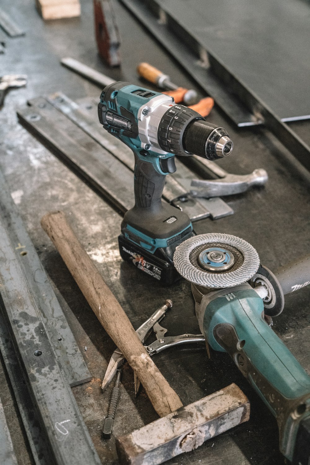 green Makita cordless drill near angle grinder