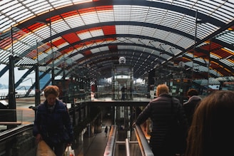 people riding escalator inside building