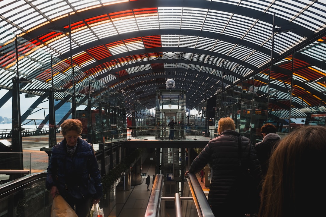 people riding escalator inside building,