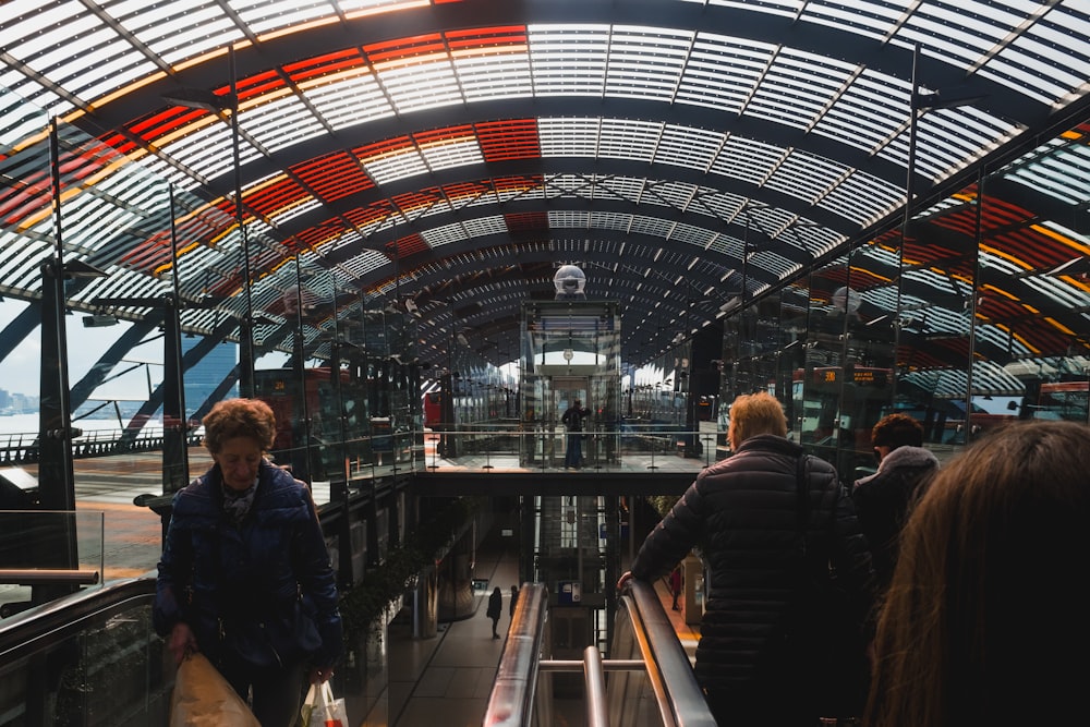 people riding escalator inside building