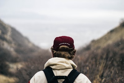 selective focus photography of person viewing mountains faceless teams background