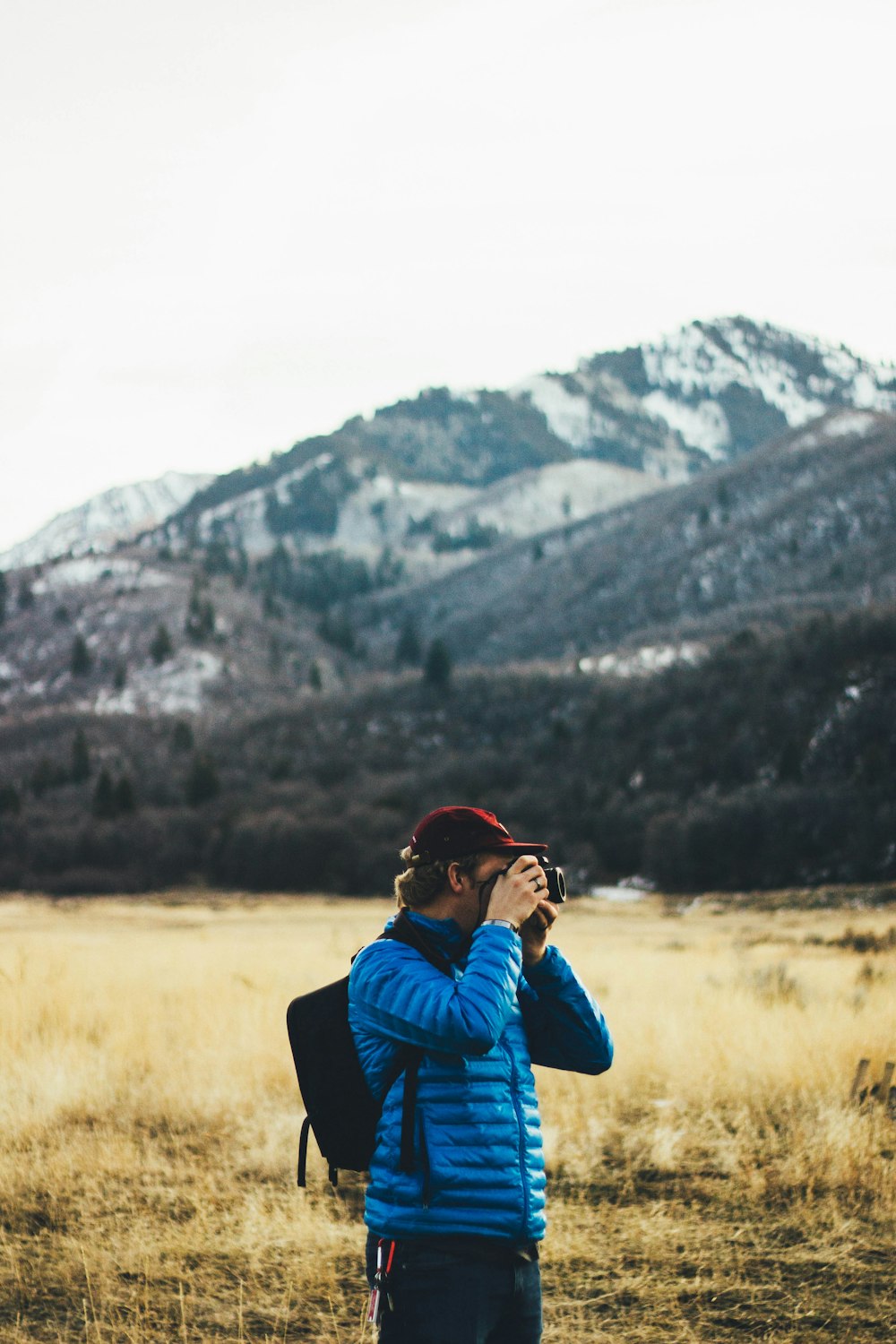 man standing near mountain taking photo