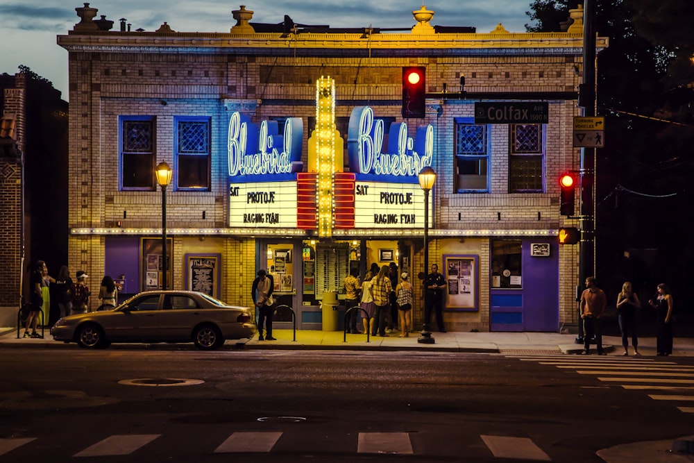 people gathering in front of theater during day