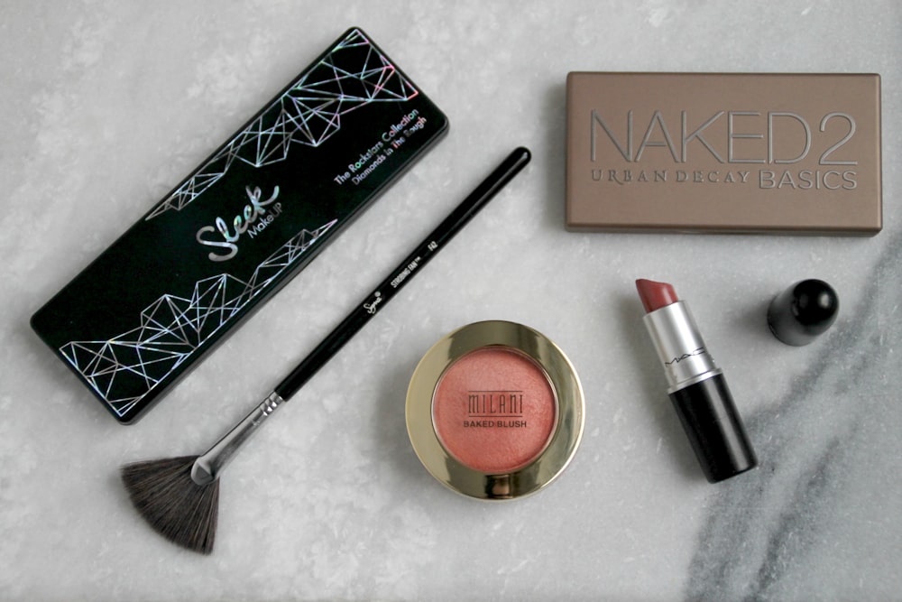 schwarzer Make-up-Pinsel, Lippenstift und Rouge auf Puder